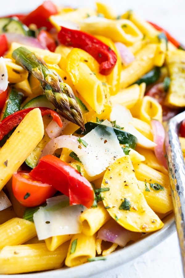 Roasted asparagus, zucchini, yellow squash, and bell peppers with vegan and gluten-free penne pasta.