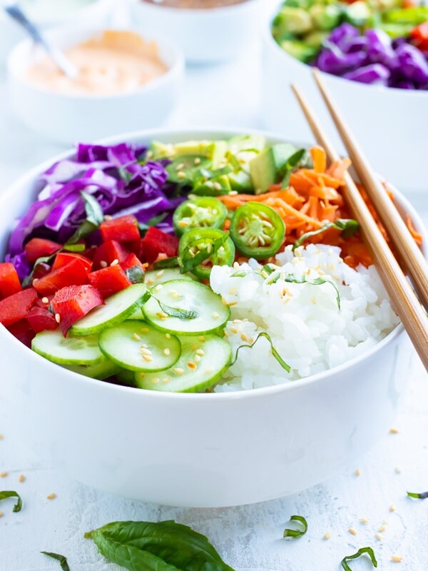 Vegan sushi bowls made with perfect sushi rice, cucumbers, bell peppers, avocado, carrots, and cabbage.