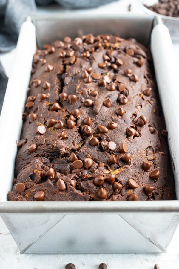 A loaf pan full of a healthy chocolate breakfast bread recipe with chocolate chips.