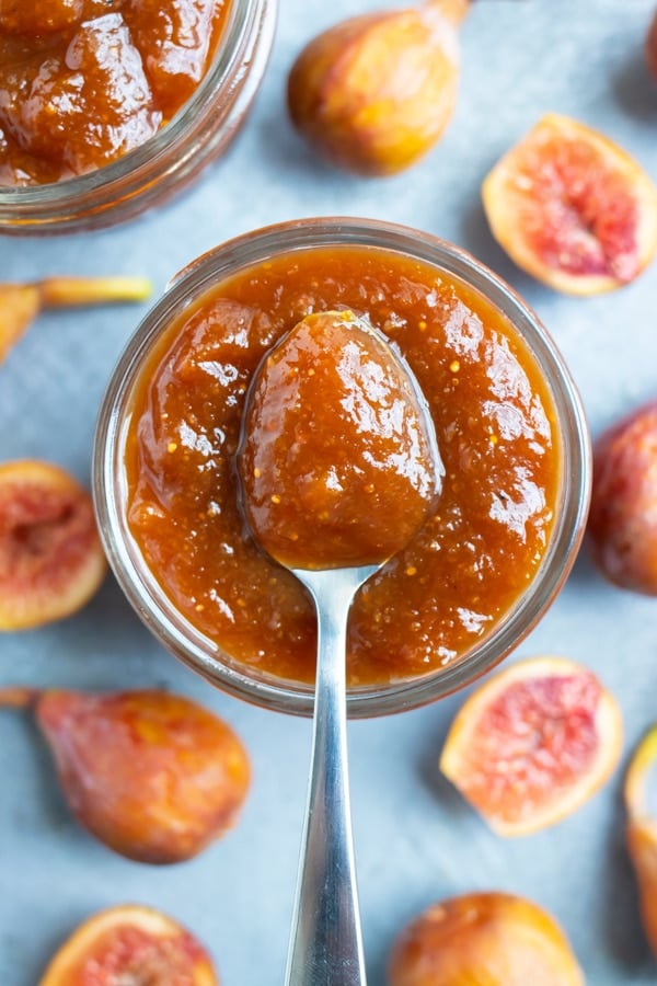 A silver spoon sitting on top of a jar full of homemade fig preserves.