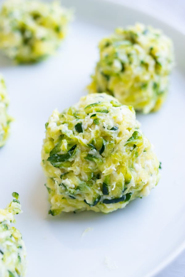 Zucchini fritters shaped into a ball before frying.