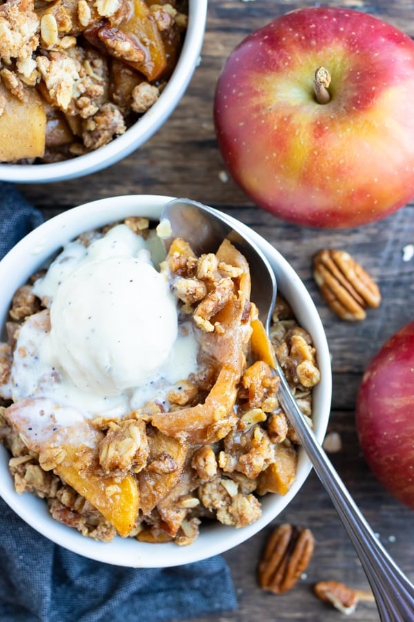 Two dessert bowls full of a gluten-free apple crisp recipe with oats and pecans.