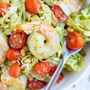 An easy pasta dinner recipe with pesto sauce, tomatoes, and shrimp.