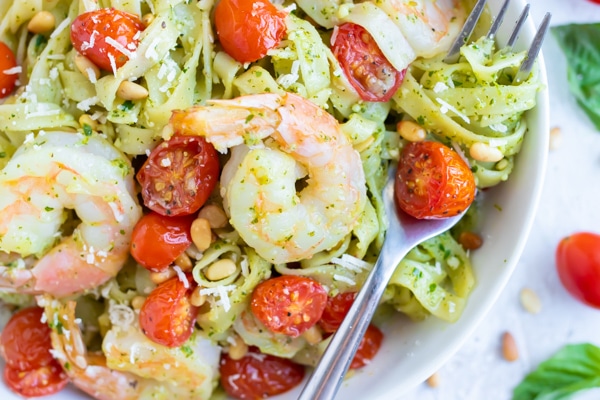 An easy pasta dinner recipe with pesto sauce, tomatoes, and shrimp.