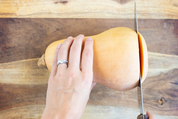 Trimming the ends of a butternut squash with a knife.