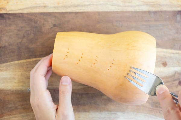 Poking holes in the skin of a squash.