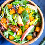 A healthy Fall salad recipe for Thanksgiving dinner with apples, pecans, butternut squash, and pumpkin seeds.