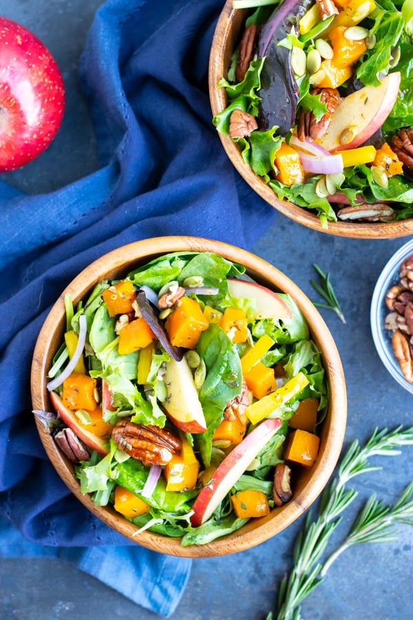 Two bowls full of a healthy, vegan, Fall harvest salad with apples and pecans.