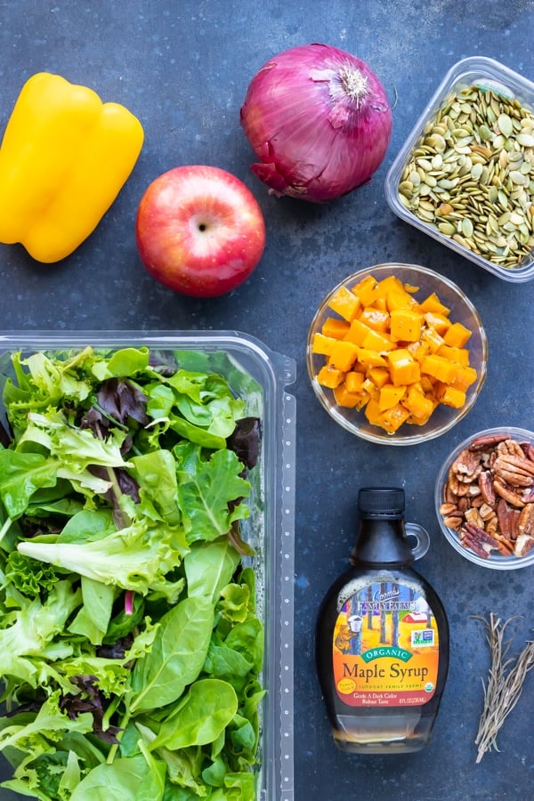 Mixed salad greens, apple, pumpkin seeds, pecans, bell pepper and onion as the ingredients in a Fall salad recipe.