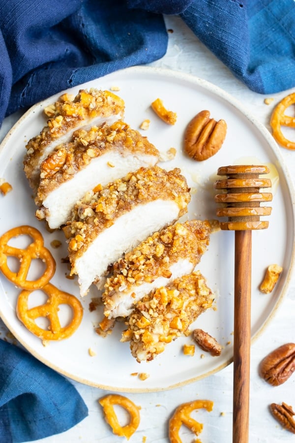 A pecan crusted chicken breast that has been cut into slices and drizzled with a honey glaze.