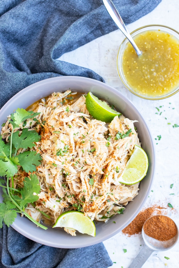A grey serving bowl full of shredded salsa verde chicken that was made in an Instant Pot.