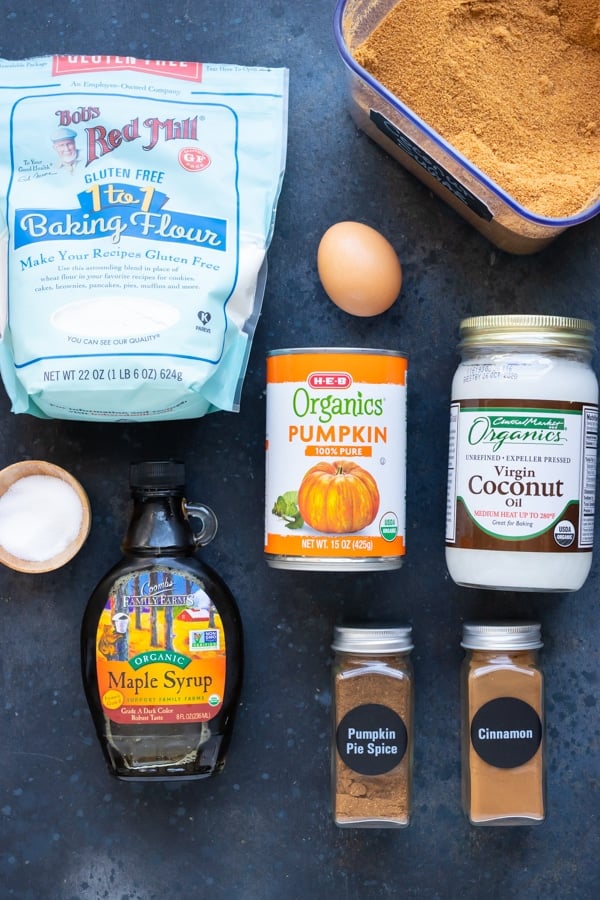 Gluten-free pumpkin muffin recipe ingredients laid out on a black background.