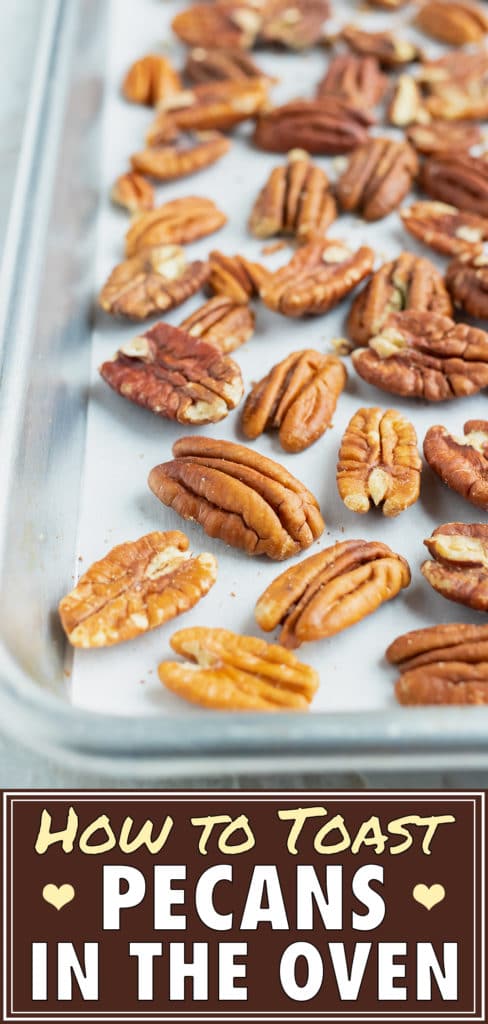 Toasted pecans on a large baking sheet that are going to be roasted in the oven.