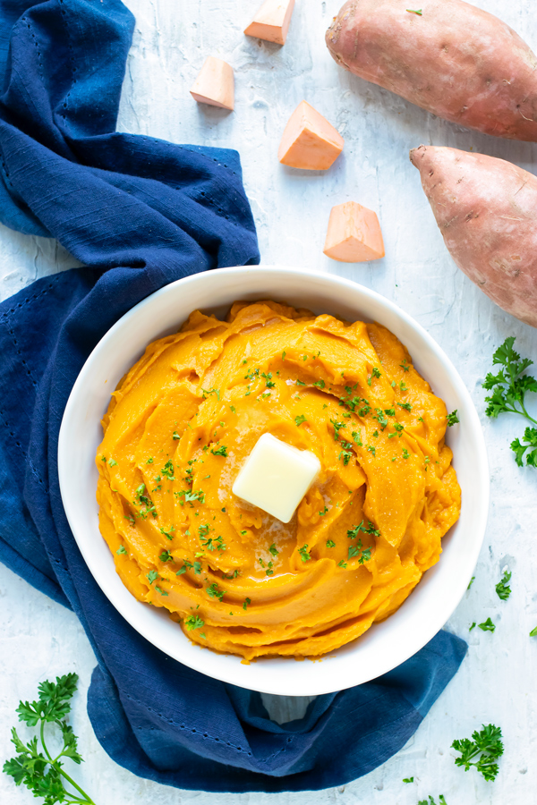 A white bowl full of easy, healthy, and Paleo mashed sweet potatoes recipe for a Thanksgiving or Christmas side dish.