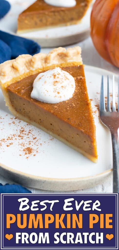 A slice of the best pumpkin pie recipe from scratch with whipped cream and cinnamon sticks next to it.