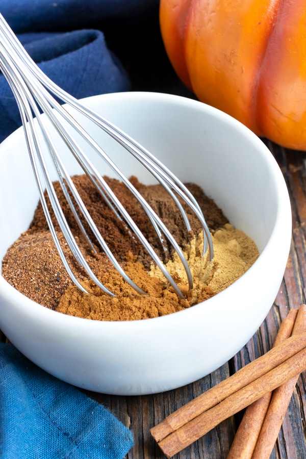 A bowl full of spices showing how to make pumpkin pie spice.