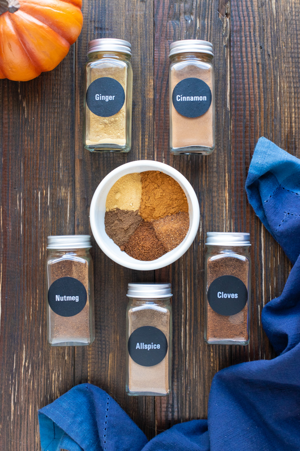 Cinnamon, nutmeg, ginger, cloves, and allspice in a white bowl for a pumpkin spice recipe.