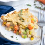 A slice of a gluten-free and dairy-free chicken pot pie recipe on a white plate with a fork.