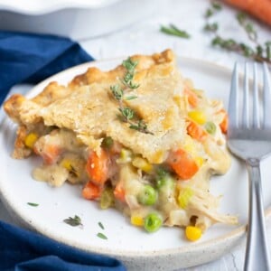 A slice of a gluten-free and dairy-free chicken pot pie recipe on a white plate with a fork.