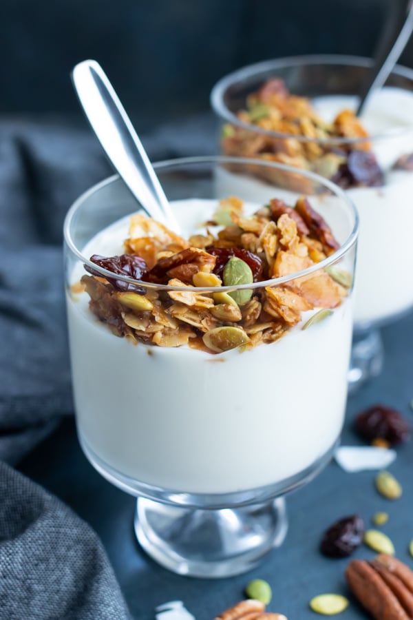 Yogurt in a glass with healthy granola on top for an easy breakfast recipe idea.