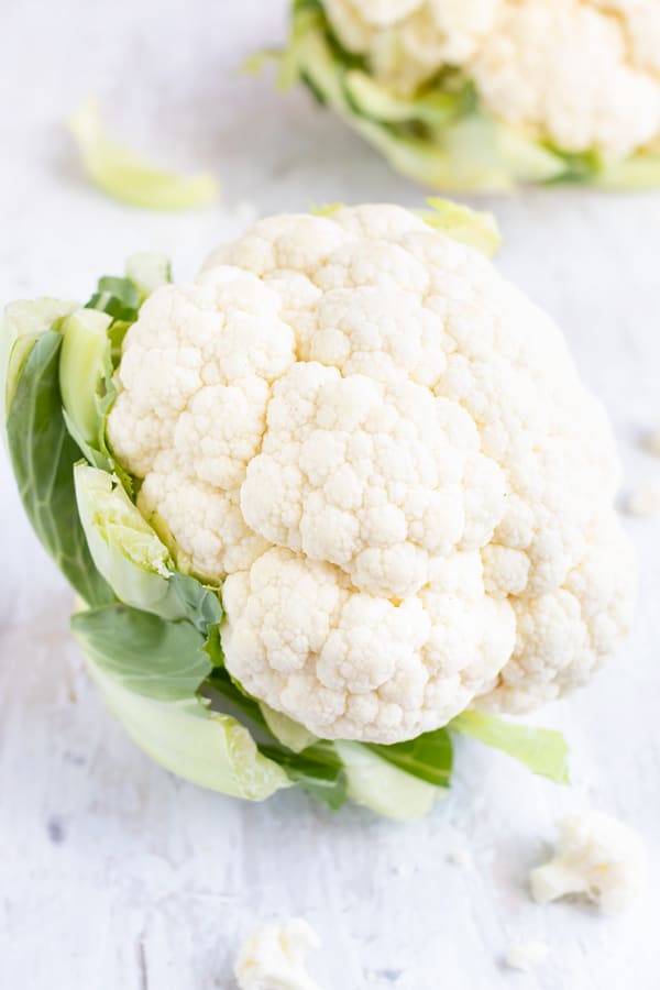 Showing how to select and store cauliflower with bright white curds, green leaves, and adequate firmness.