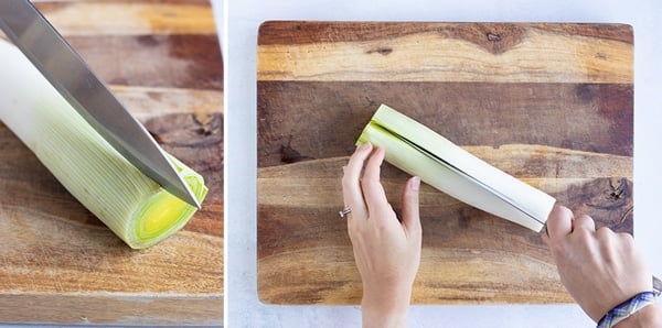 A fresh leek that is being cut down the middle lengthwise.