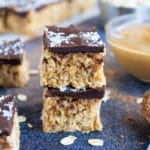 Two no-bake Samoa bars that are made with gluten-free oats, vegan shredded coconut, and peanut butter.