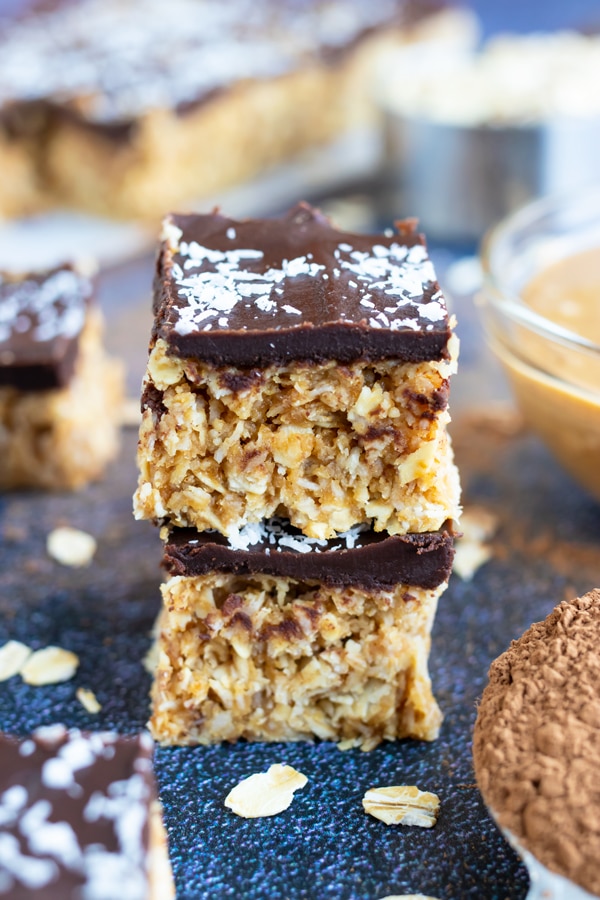 Two no-bake Samoa bars that are made with gluten-free oats, vegan shredded coconut, and peanut butter.