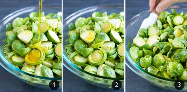 Olive oil being drizzled into a bowl full of sliced Brussels sprouts that are then tossed with a spatula.