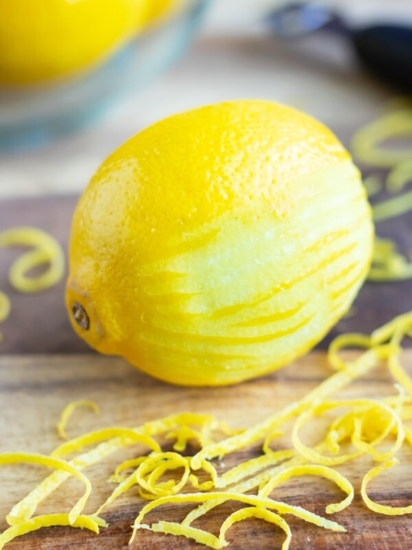 A lemon showing the pith and the peel after being zested with a citrus zester.