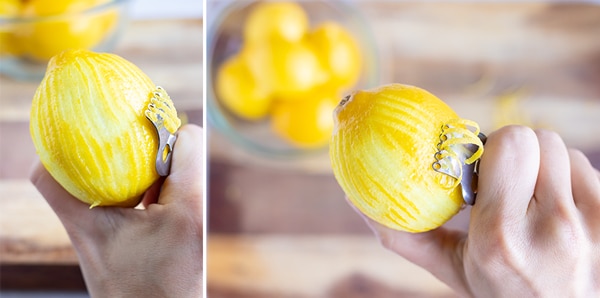 A hand removing the zest from a lemon using a citrus zester.