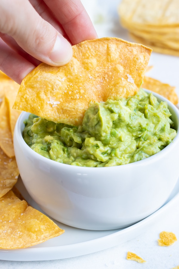 A chip being dipped into guacamole.