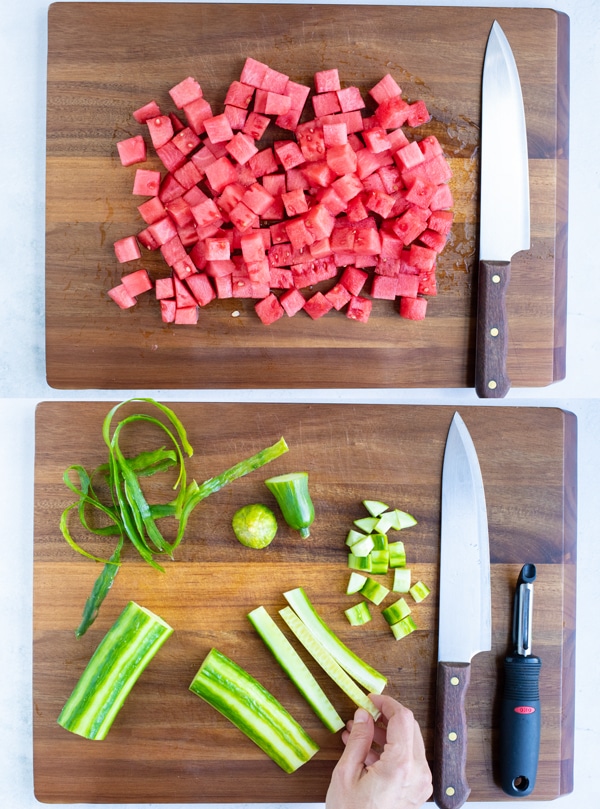 Cubed watermelon and peeled and diced cucumber on a wooden cutting board.