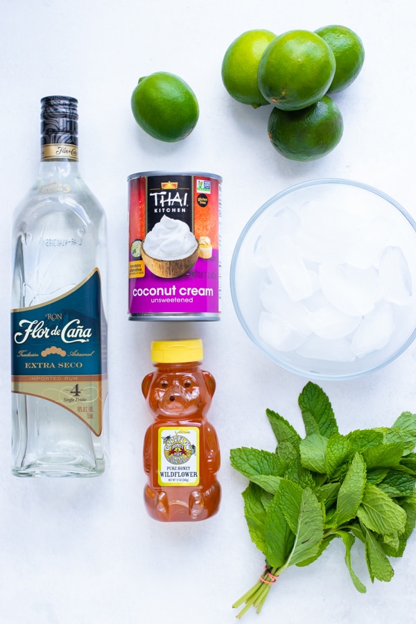 Rum, mint, limes, ice, and honey as the ingredients needed in a frozen mojito recipe.