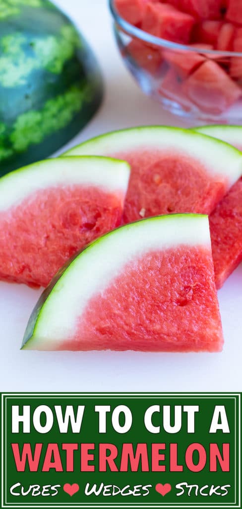 A pile of watermelon slices with a full melon in the background.