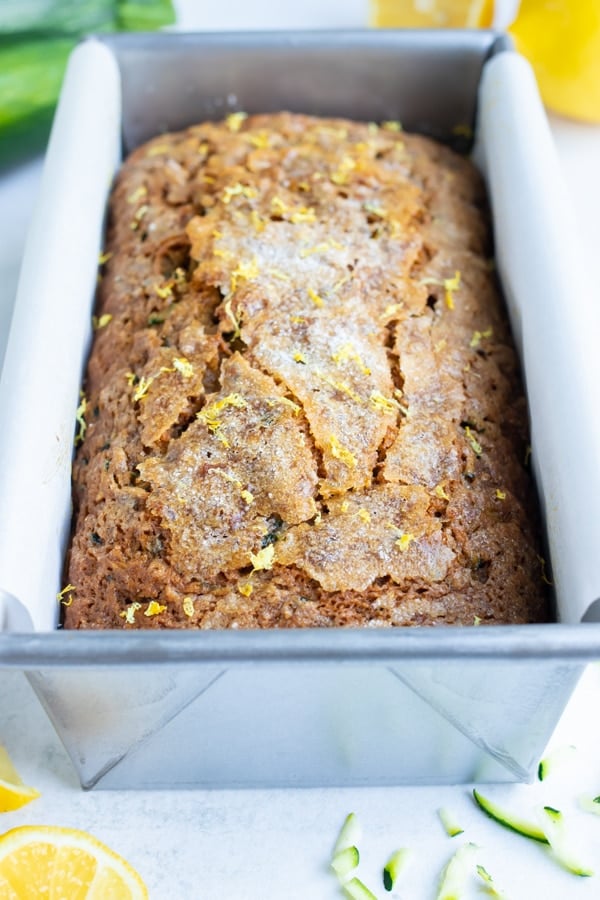 Multiple slices of gluten-free lemon zucchini bread on a white counter.