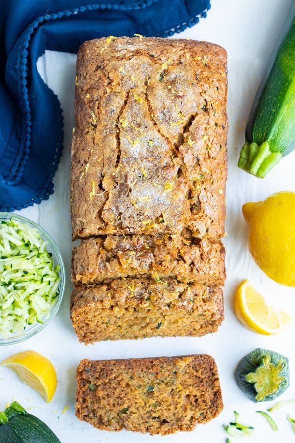 Multiple slices of gluten-free lemon zucchini bread on a white counter.