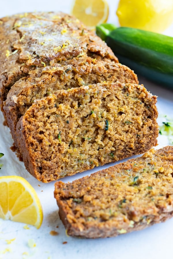 Multiple slices of gluten-free lemon zucchini bread on a white counter.