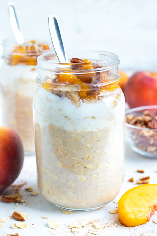 Oatmeal, yogurt, fresh peaches, and toasted pecans are combined in a mason jar for this easy overnight oats recipe.
