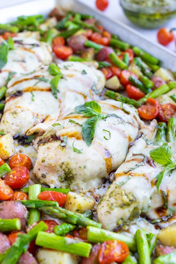This caprese chicken and vegetables is served with a drizzle of Balsamic Glaze and a sprinkle of fresh basil.
