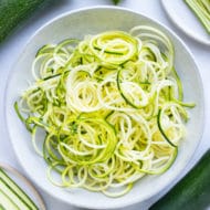 A pile of spiralized zucchini noodles in a bowl on the counter.