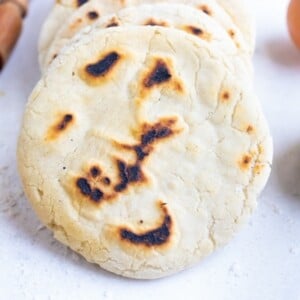 Pita bread is laid on the counter next to ingredients used in this recipe.