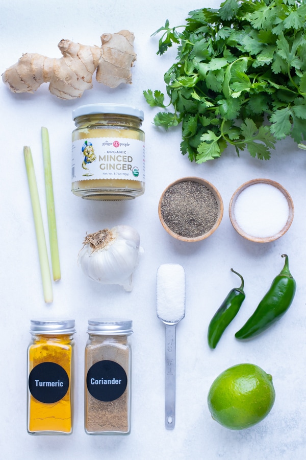 Chili peppers, garlic, cilantro, limes, ginger, lemongrass, spices, and other ingredients are used in homemade Thai green curry paste recipe.