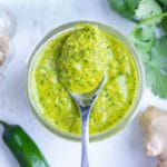 Green curry paste is stored in a glass container before being used in gluten-free Thai recipes.