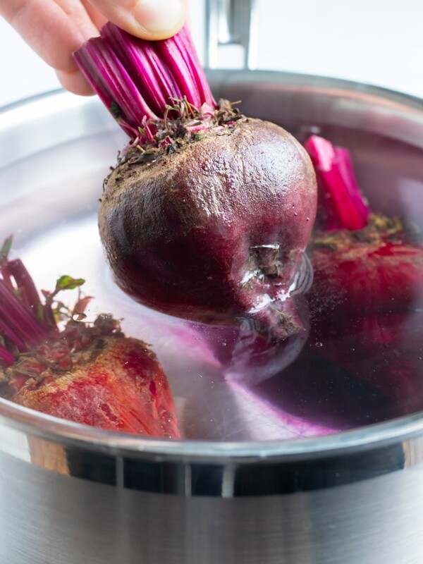 Beets are removed from the pot of water after being boiled.