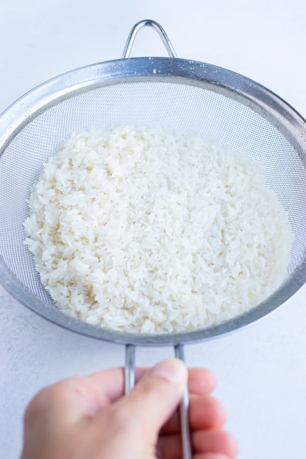Rinse long grain white rice in a colander before cooking for a fluffy texture.