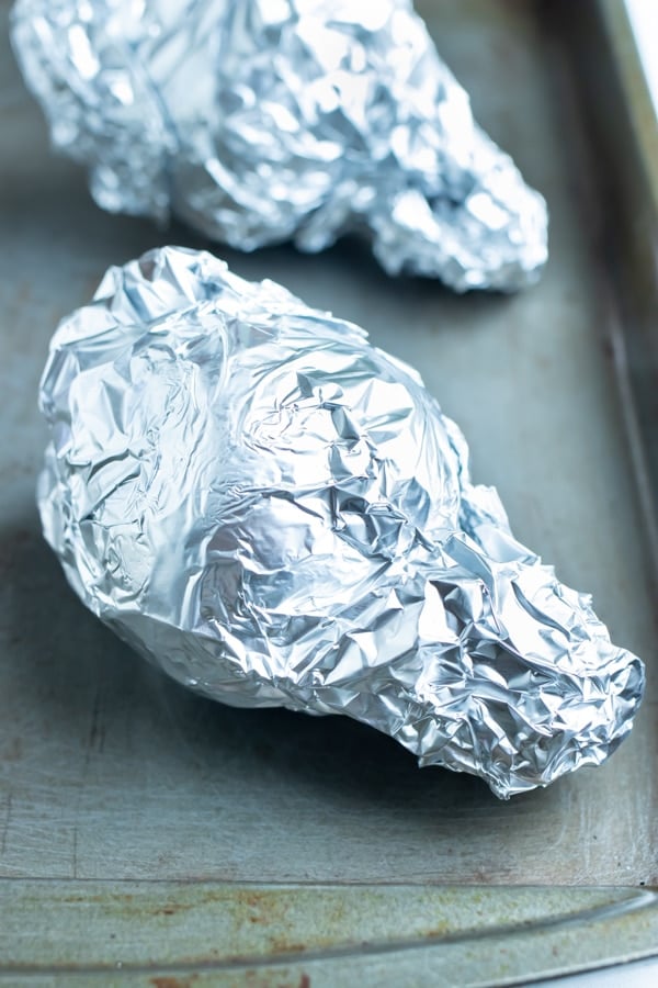 Beets are wrapped in foil and roasted in the oven on a baking sheet.