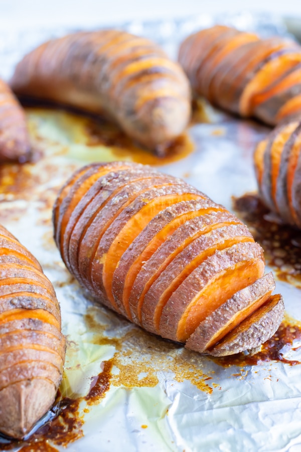 Sliced sweet potatoes are baked in the oven with brown sugar, butter, and cinnamon.