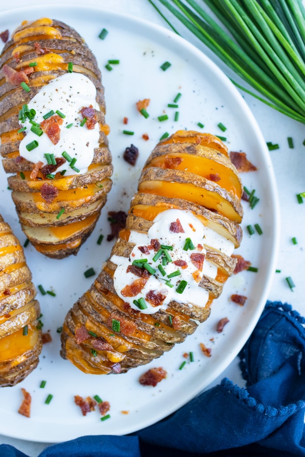 Stuffed hasselback potatoes are served on a plate for a gluten-free side dish.