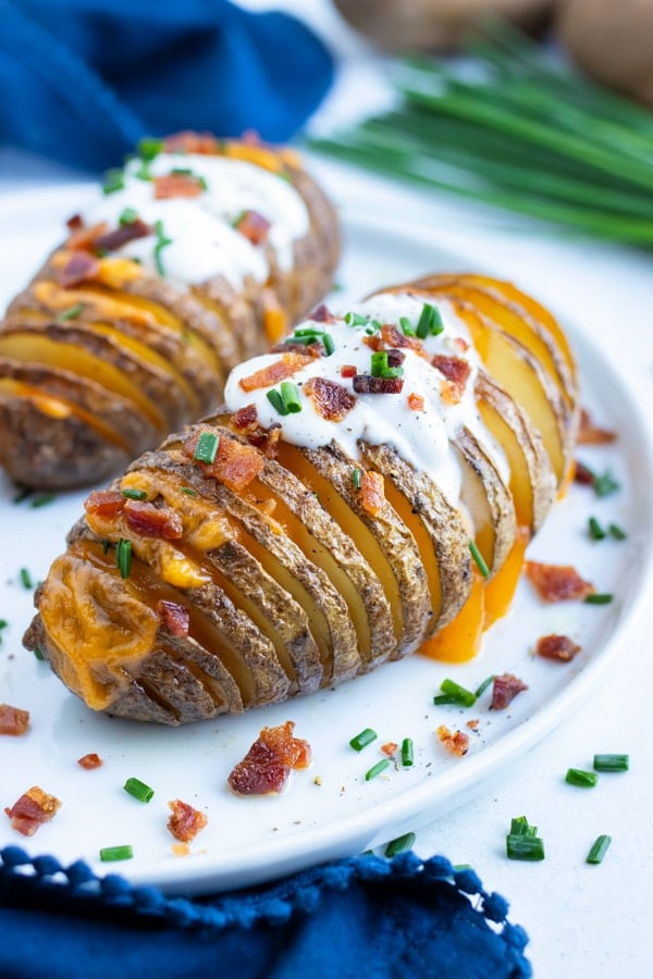 Baked loaded hasselback potatoes are filled with cheese and topped with bacon.